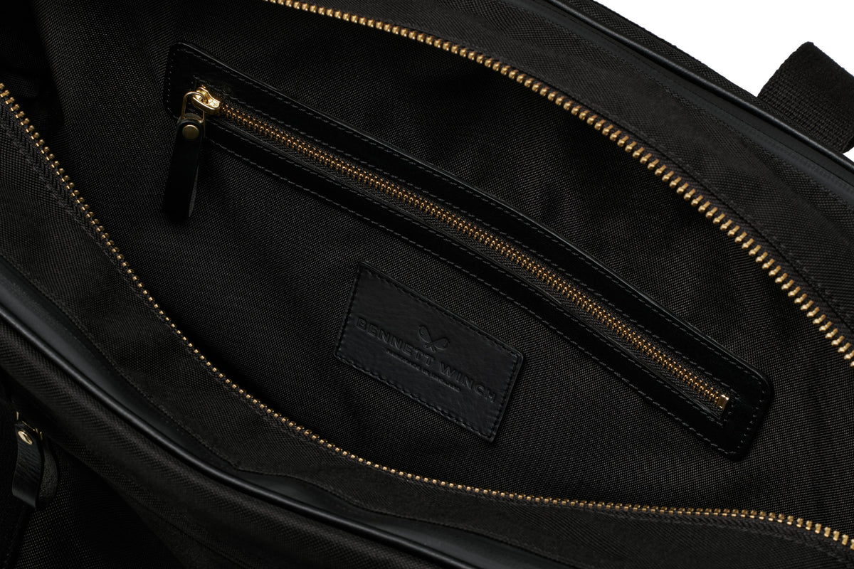 open view of the designer tennis bag in black, showing the inside pocket