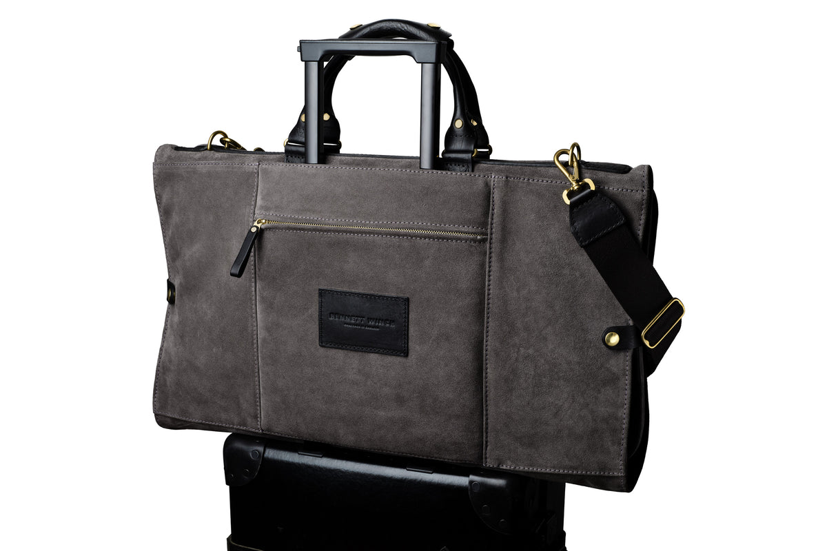 luxury grey suede trifold on top of a suitcase