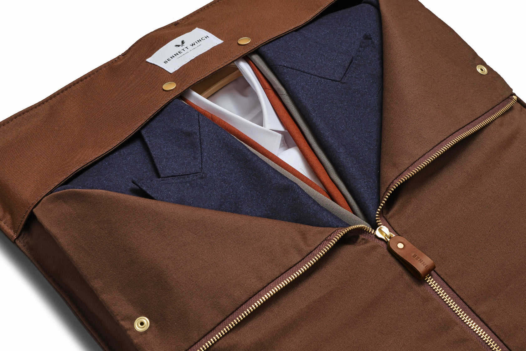a view of the inside of the brown suede trifold half zipped with clothes inside