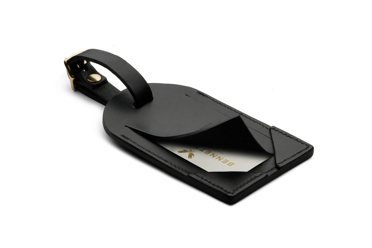 Back of a black luggage tag with opened business card concealing flap.