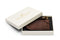 Open white box showing back of a dark brown luggage tag and leather strap with brass buckle.