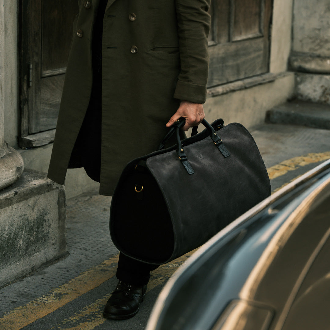 CEO walking with the suede Bennett Winch Suit Carrier