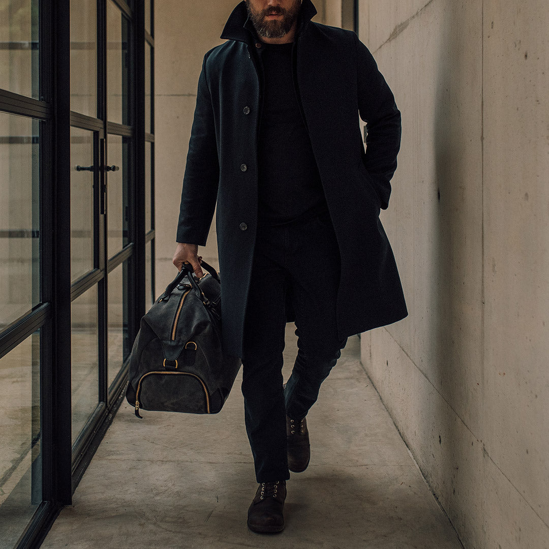 man holding the grey suede weekender bag lifestyle