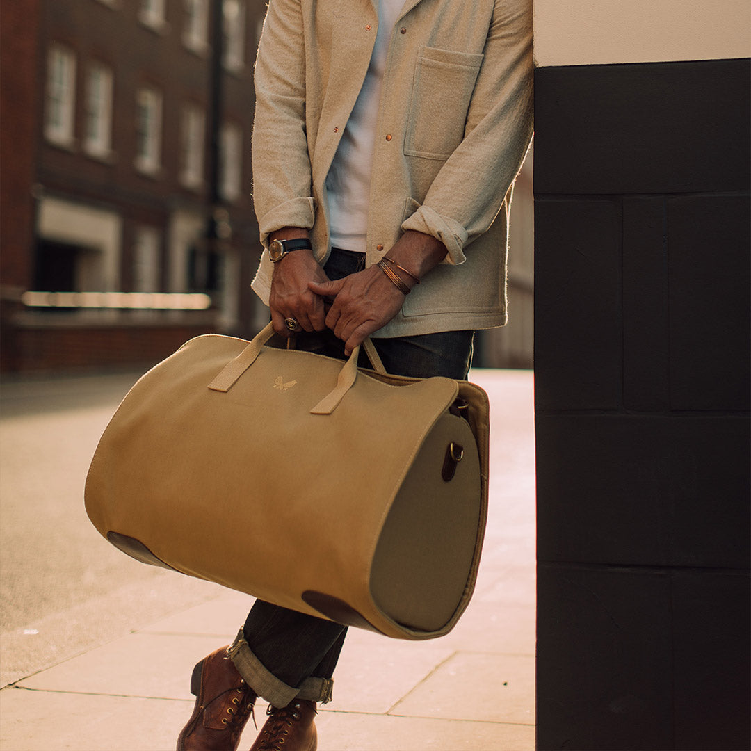 man holding tan suit carrier holdall lifestyle