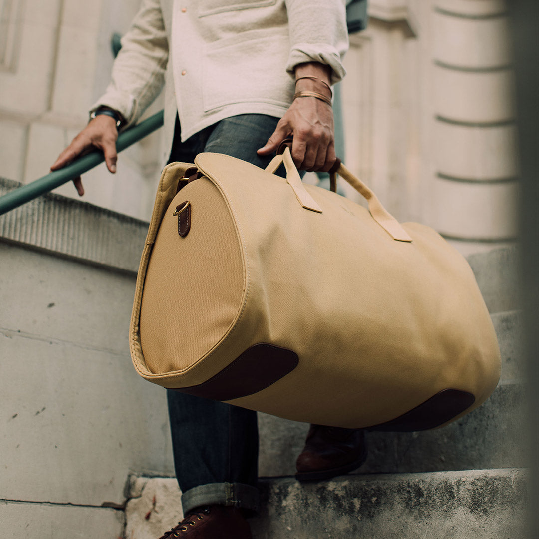 man holding Bennett Winch tan Suit Carrier Holdall lifestyle