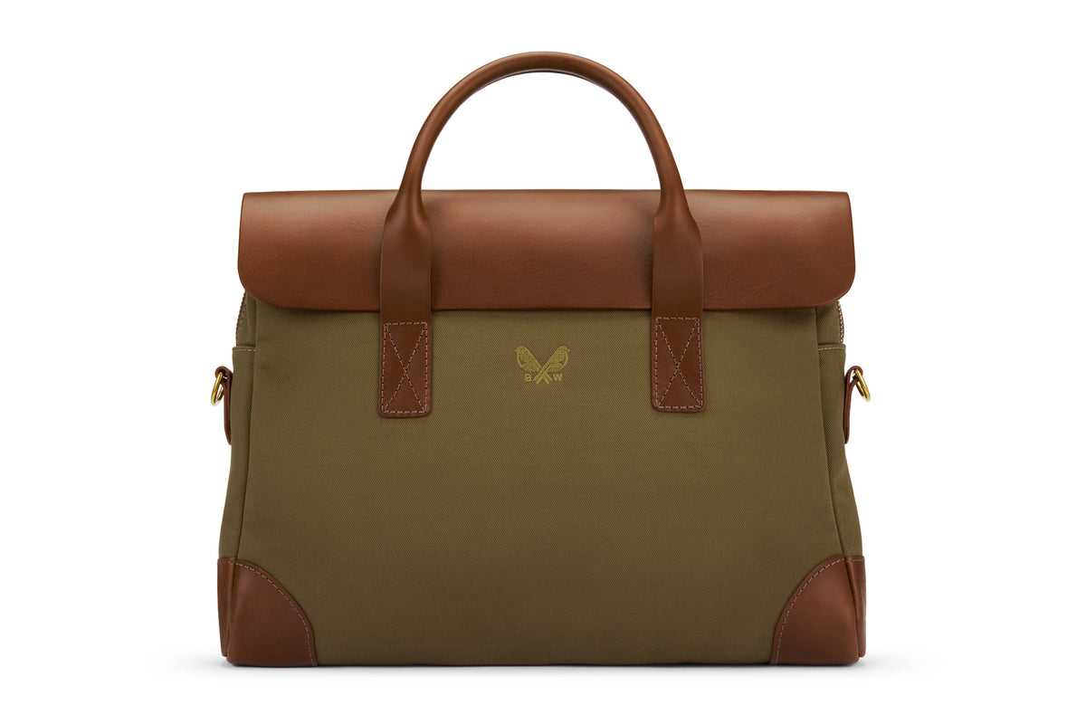An olive cotton canvas briefcase with full-grain leather trim and a shoulder strap, shown from the front.