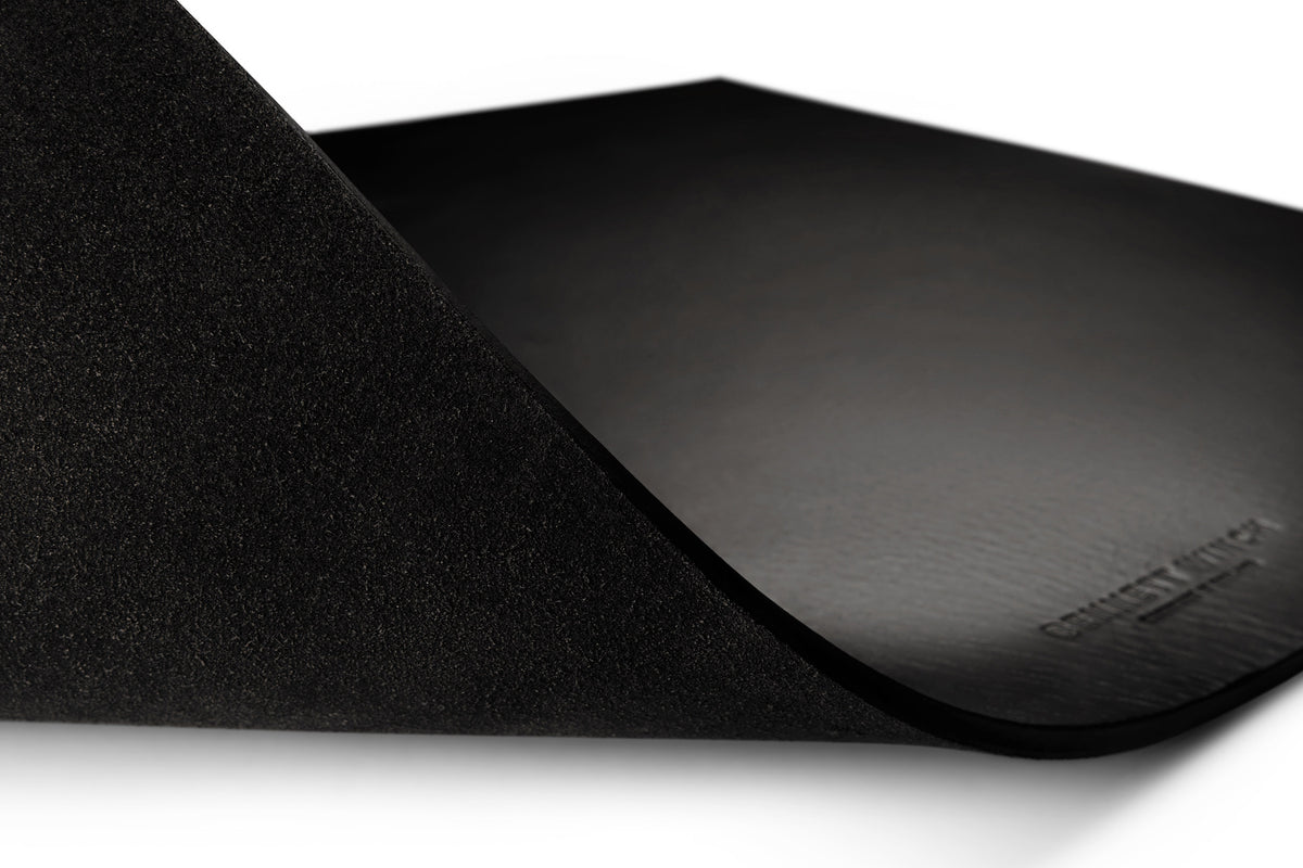 A close up of the Bennett Winch logo embossed on the black leather desk mat
