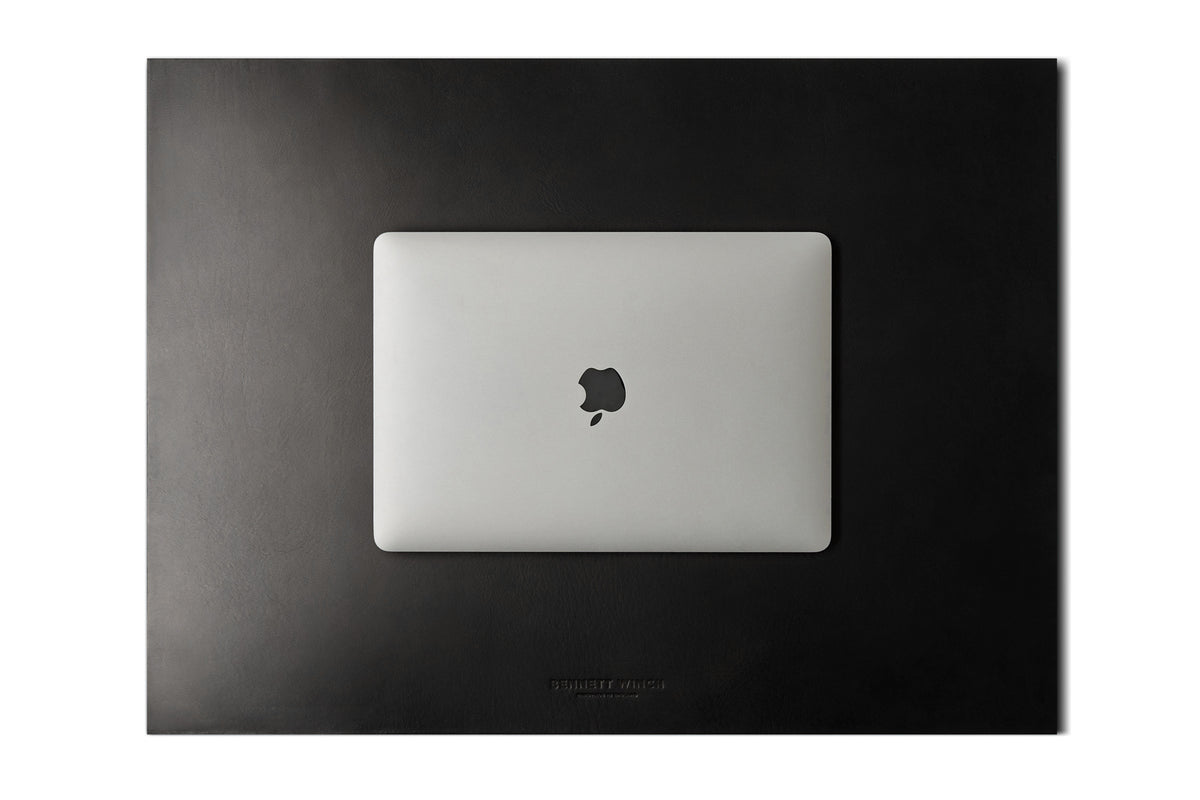 top shot of the Italian veg tanned black leather desk blotter and a closed laptop on top