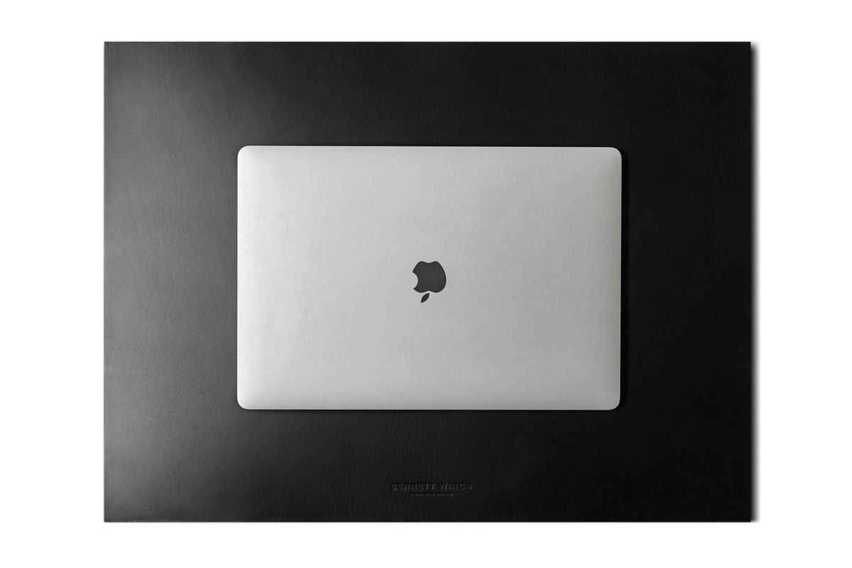 Top shot of the black leather desk mat set up with a full iMac, keyboard and mouse