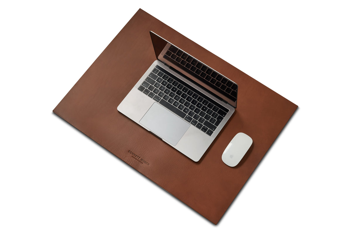 brown leather desk mat with a MacBook and mouse
